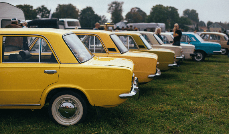 A photo of some classic cars parked in a row for a car show
